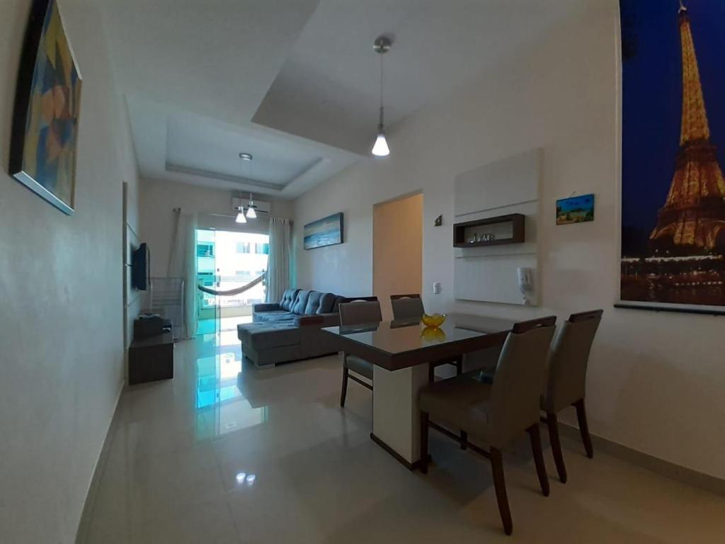 a living room with a table and chairs and a couch at Apartamento Terra Nova Mariscal in Bombinhas