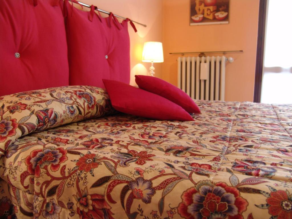 Un dormitorio con una cama con almohadas rojas. en B&B Il Fragolo, en Verona