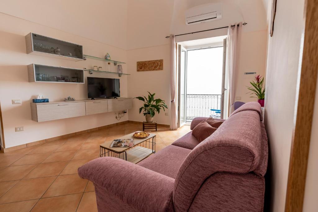 salon z fioletową kanapą i telewizorem w obiekcie Casa Vacanza da Giggino w mieście Ravello