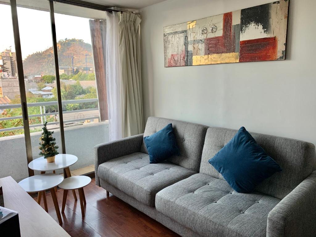 uma sala de estar com um sofá e uma janela em Depto. Excelente vista al Cerro San Cristobal !! em Santiago