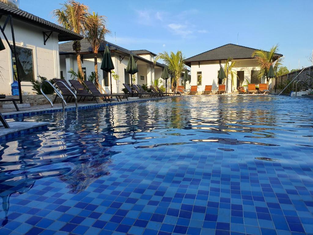 フーコックにあるCoco Village Phu Quoc Resort & Spaのリゾート内の青いタイルのスイミングプール