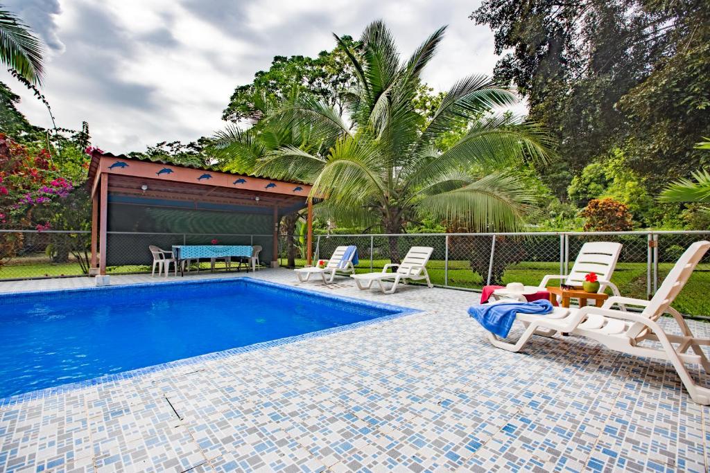 a swimming pool with two chairs and a table and a tablektop at Casa Margarita in Puerto Viejo