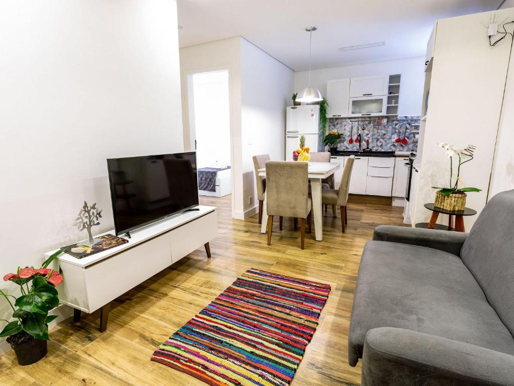 sala de estar con sofá y TV y cocina en Apartamento com 2 Quartos em Alto de Pinheiros en São Paulo