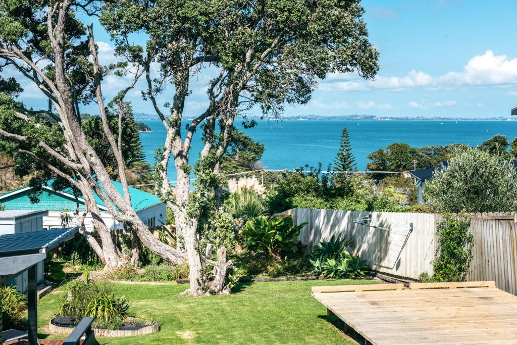a garden with a view of the ocean at Pohutukawa Cottage, Waiheke Island in Oneroa