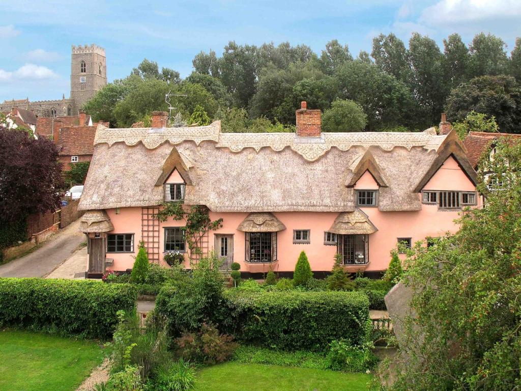 een groot roze huis met een rieten dak bij Old Drift House in Kersey