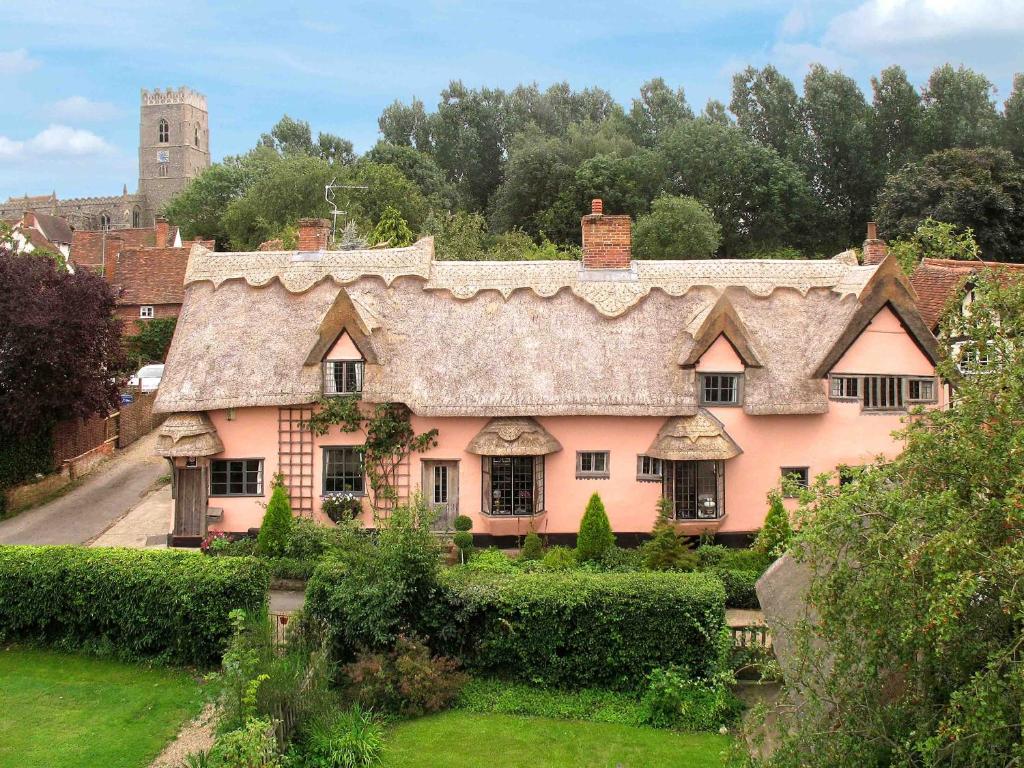 a large pink house with a thatched roof at Old Drift House in Kersey