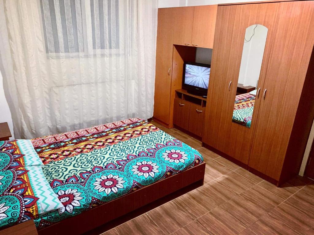 a small bedroom with a bed and a mirror at Militari Residence Studio in Roşu