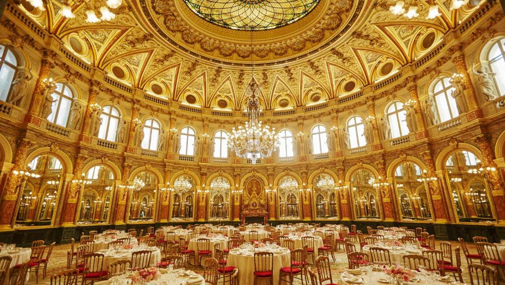 a large room filled with tables in a building at InterContinental Paris Le Grand by IHG in Paris