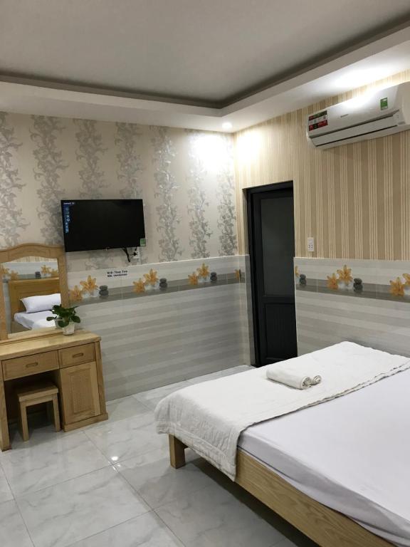 a bedroom with a bed and a flat screen tv at MOTEL THỦY TIÊN in Vung Tau