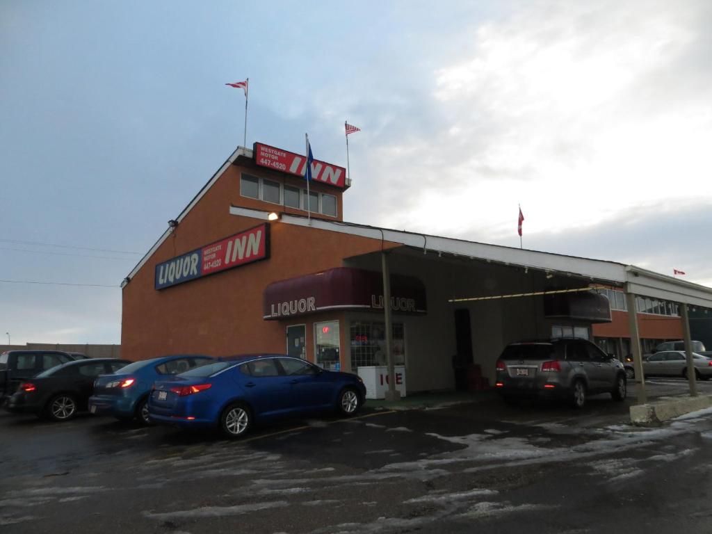 a store front with cars parked in a parking lot at Westgate Inn in Edmonton