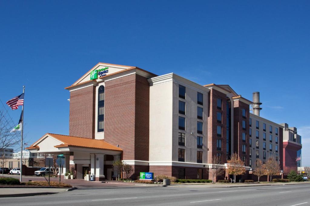 Um grande edifício com uma bandeira americana à frente. em Holiday Inn Express Hotel & Suites Indianapolis Dtn-Conv Ctr, an IHG Hotel em Indianápolis