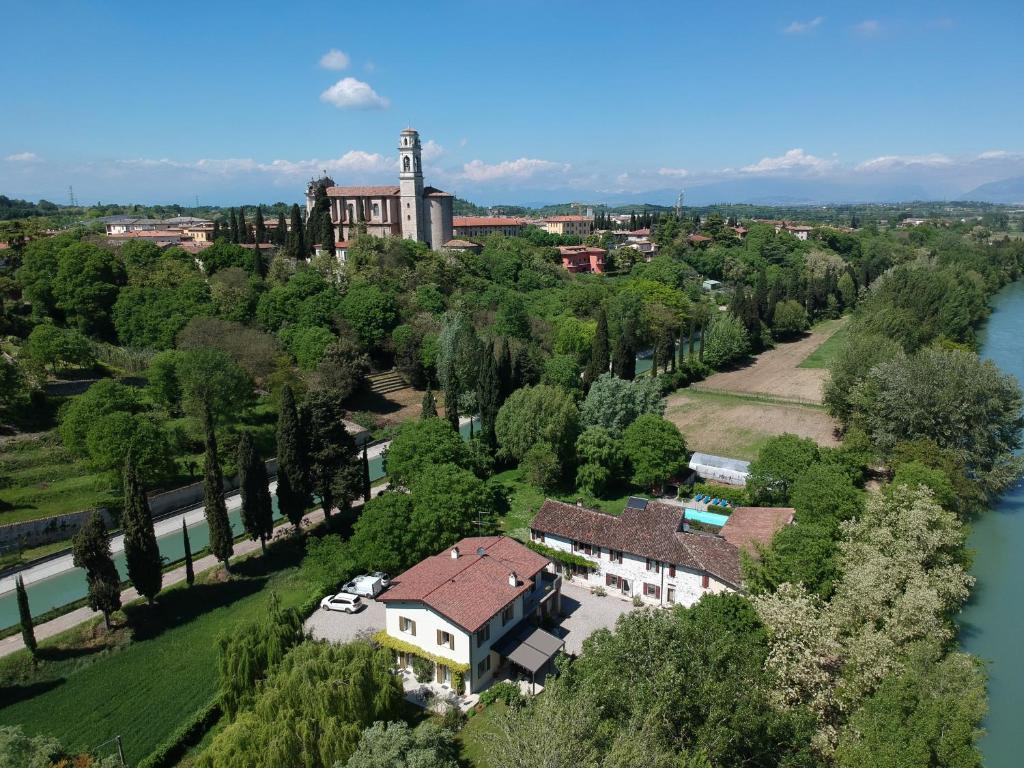 una vista aérea de un edificio en una colina junto a un río en L'Isolo b&b e case vacanza, en Monzambano