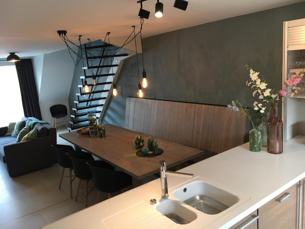a kitchen and living room with a table and a staircase at ABC Apartment in Blankenberge