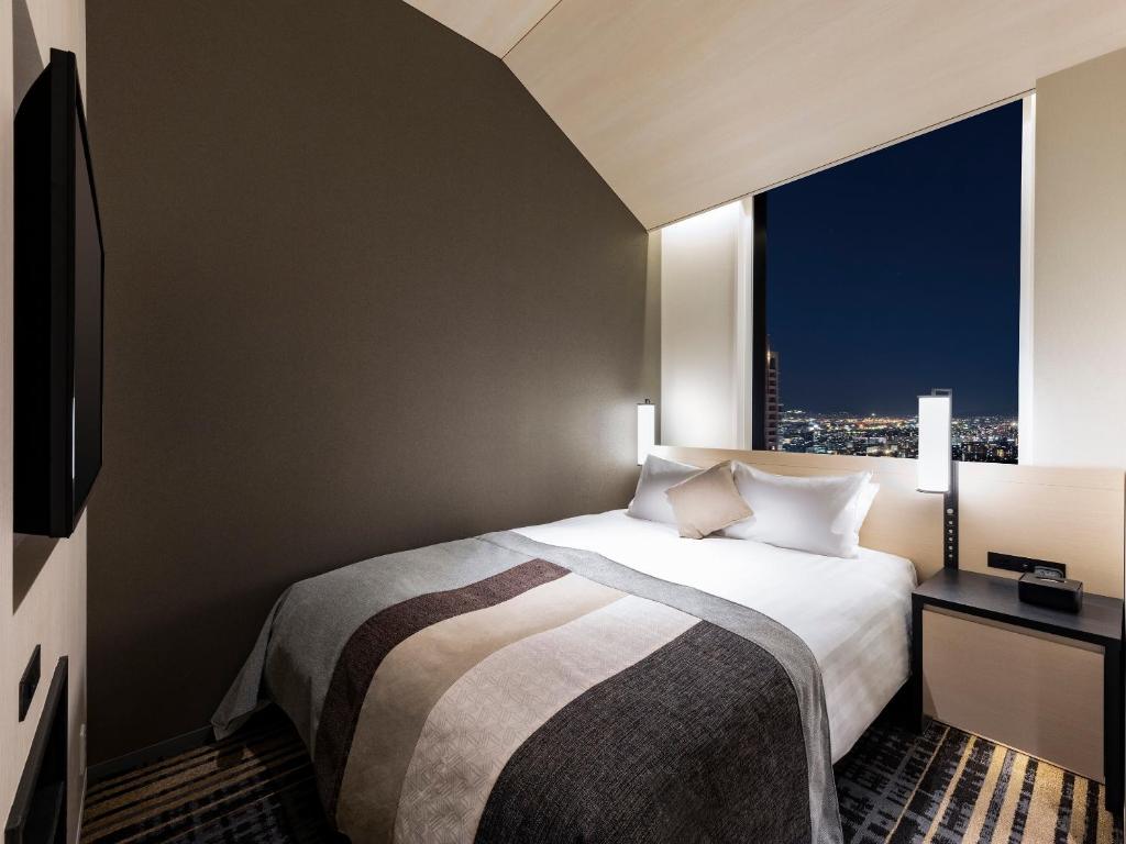 Postel nebo postele na pokoji v ubytování Hotel Hankyu RESPIRE OSAKA