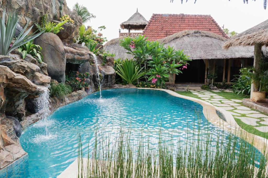 a swimming pool with a waterfall in a resort at Puri Samaira in Tanjung