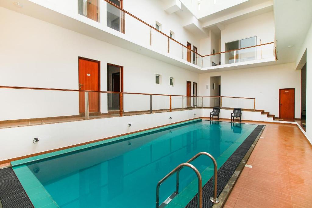 een binnenzwembad met blauw water in een gebouw bij Meth Suites in Epamulla