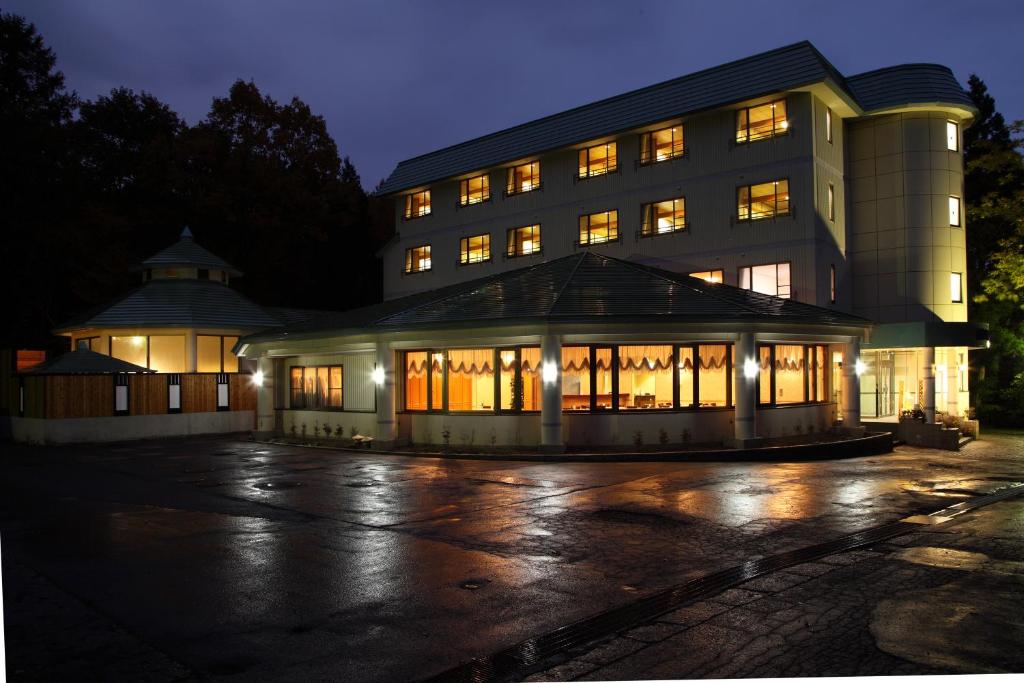 un bâtiment la nuit avec ses lumières allumées dans l'établissement Hotel Oak Forest, à Hakuba