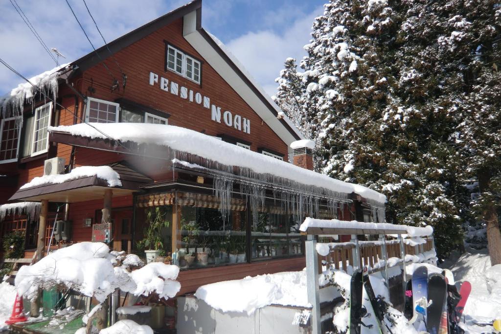 a building with snow on the front of it at Pension Noah in Yuzawa