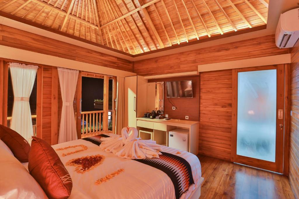a bedroom with a bed in a room with wooden walls at Sunrise Cottage in Nusa Penida