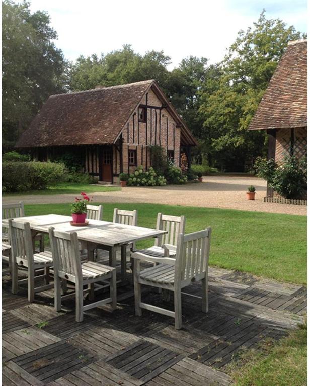 une table et des chaises en bois avec une table et un bâtiment dans l'établissement La rabouillere, à Contres
