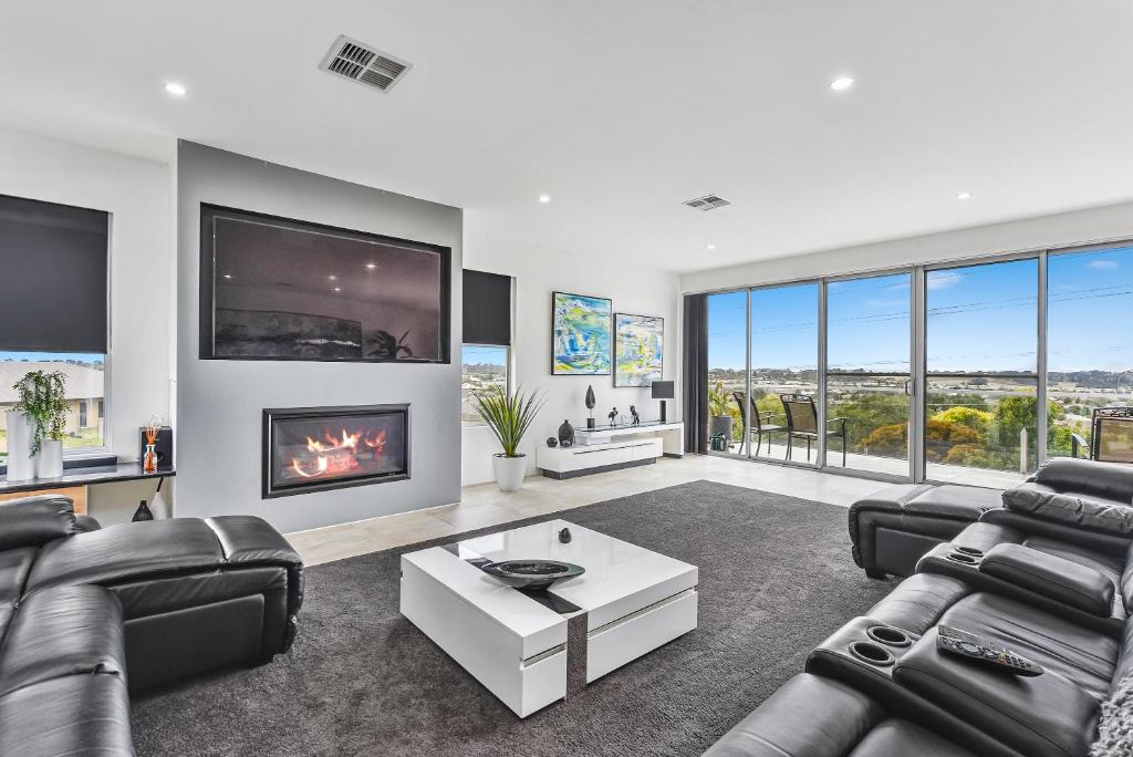 a living room with leather furniture and a fireplace at CONROE EXECUTIVE TOWNHOUSE - MODERN & STYLISH in Mount Gambier