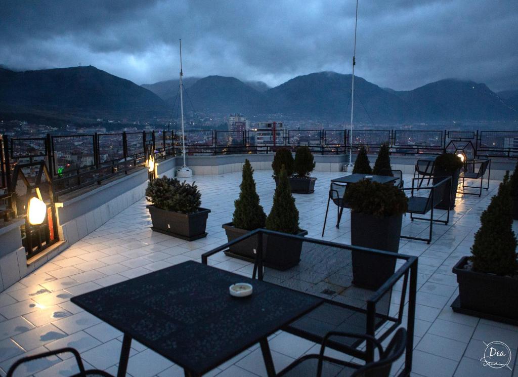 un patio con tavoli e sedie sul tetto di Suite Terrace Rooms & Apartments a Korçë