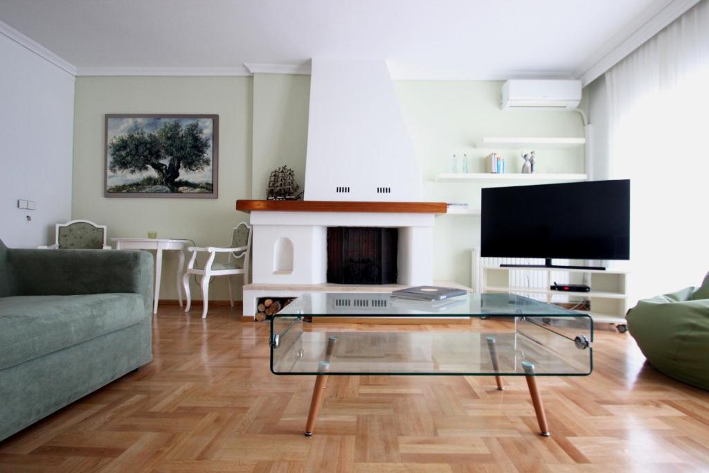 a living room with a couch and a tv at Cozy Penthouse in Thessaloniki