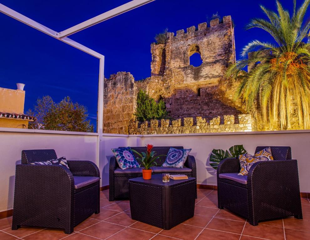 een kamer met twee banken en een schilderij van een kasteel bij RENOVATED HOUSE IN OLD TOWN MARBELLA. in Marbella