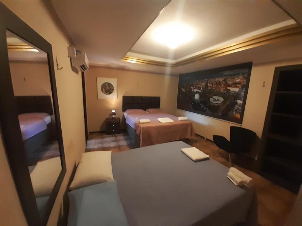 Cette petite chambre comprend un lit et un miroir. dans l'établissement Hotel Nacional, à Sobral