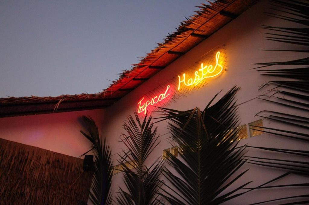 帕延島的住宿－Tropical Hostel，建筑物一侧的 ⁇ 虹灯标志