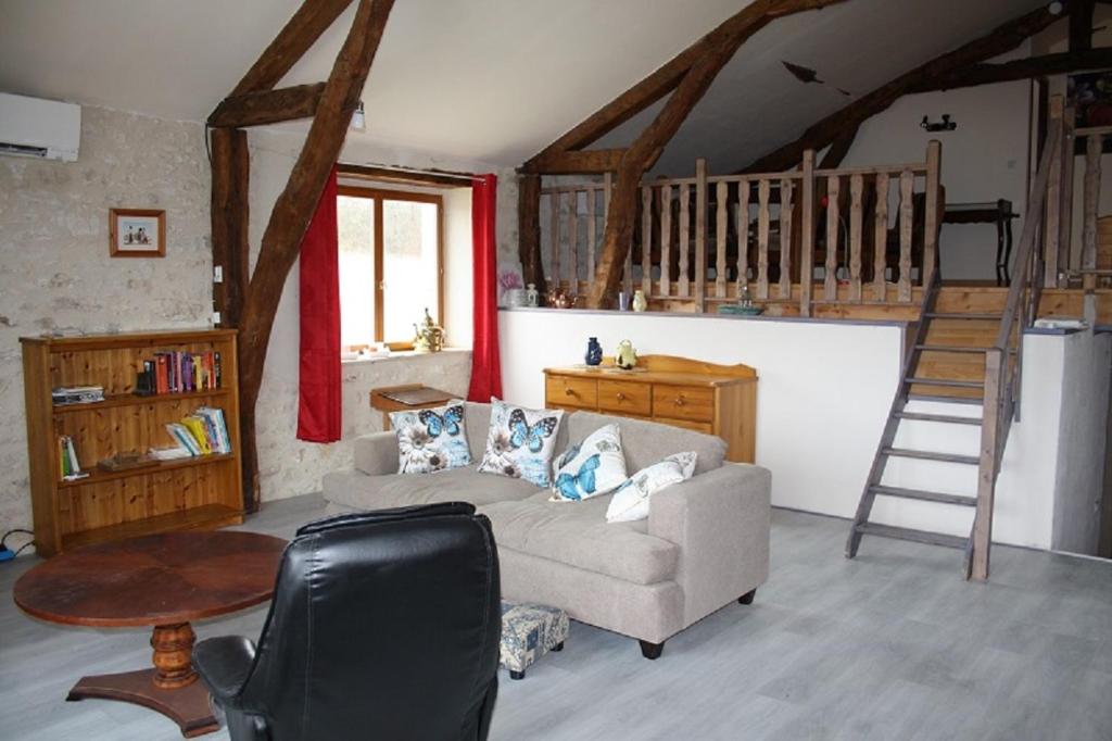 ein Wohnzimmer mit einem Sofa und einer Treppe in der Unterkunft la perle du lot gite 5 places in Castelnau-de-Montratier