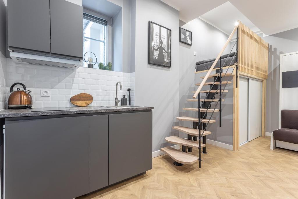 une cuisine avec un escalier en colimaçon dans une pièce dans l'établissement Lumignons Lyonnais - Presqu'île Confluence, à Lyon