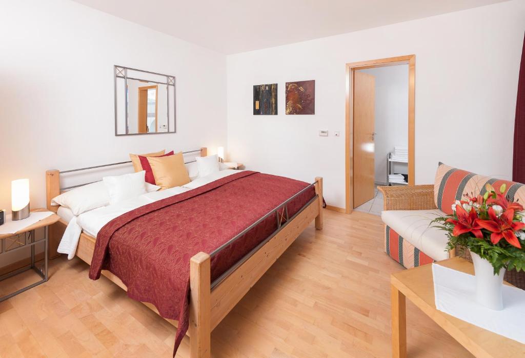 ein Schlafzimmer mit einem großen Bett und einer Couch in der Unterkunft Gästehaus & Weingut PETH in Flörsheim-Dalsheim