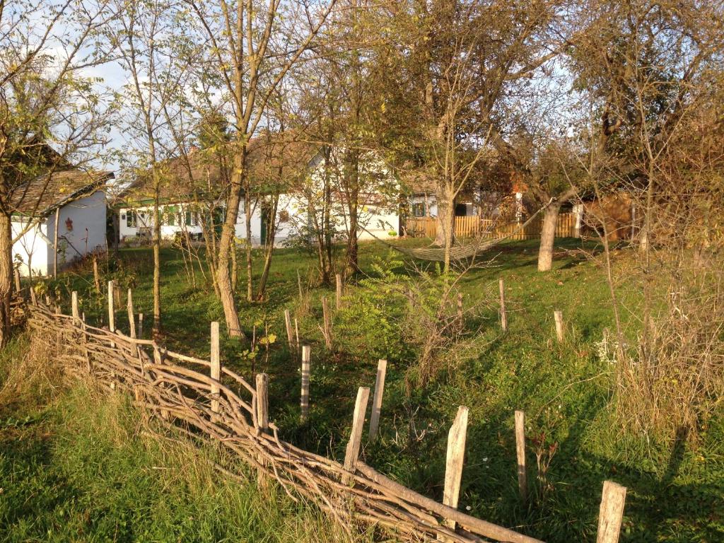 a fence in a field next to a house at Erdősmecskei sváb vendégházak és Jurtaszállás in Erdősmecske