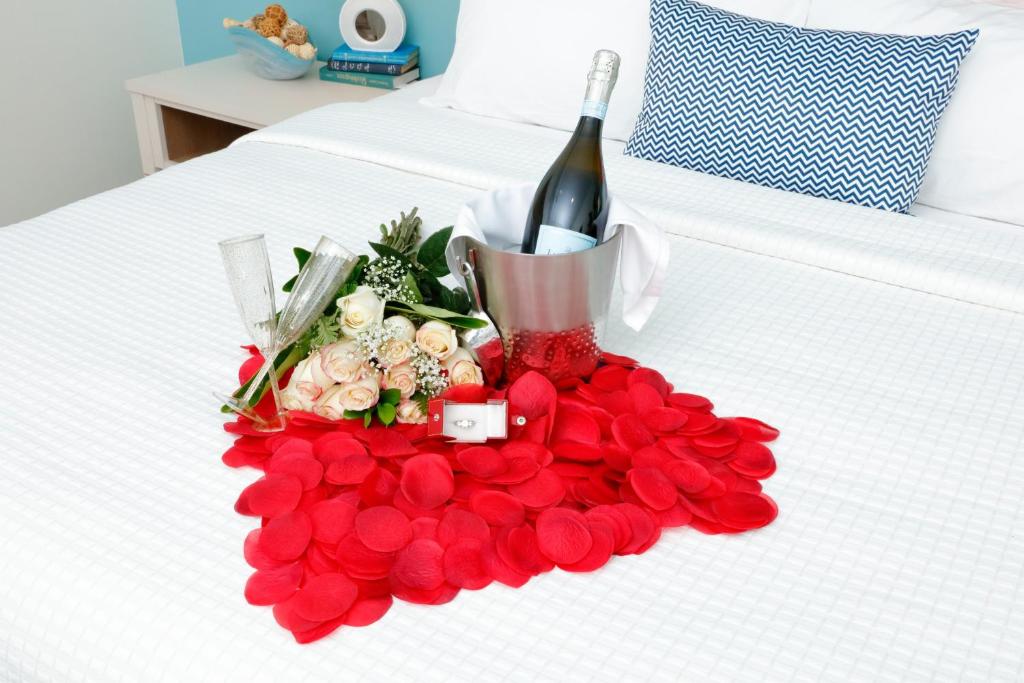 einen Rosenstrauß und eine Flasche Wein auf dem Bett in der Unterkunft Hotel Indigo Orange Beach - Gulf Shores by IHG in Gulf Shores