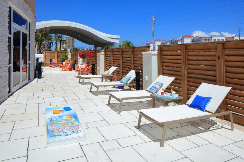 a row of lounge chairs sitting on a patio at Hotel Indigo Orange Beach - Gulf Shores by IHG in Gulf Shores