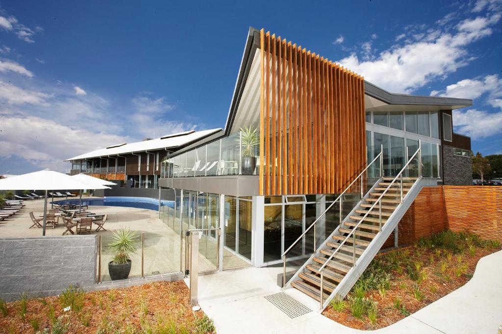 une maison en verre avec un escalier en face de celle-ci dans l'établissement Silverwater Resort Phillip Island, à San Remo