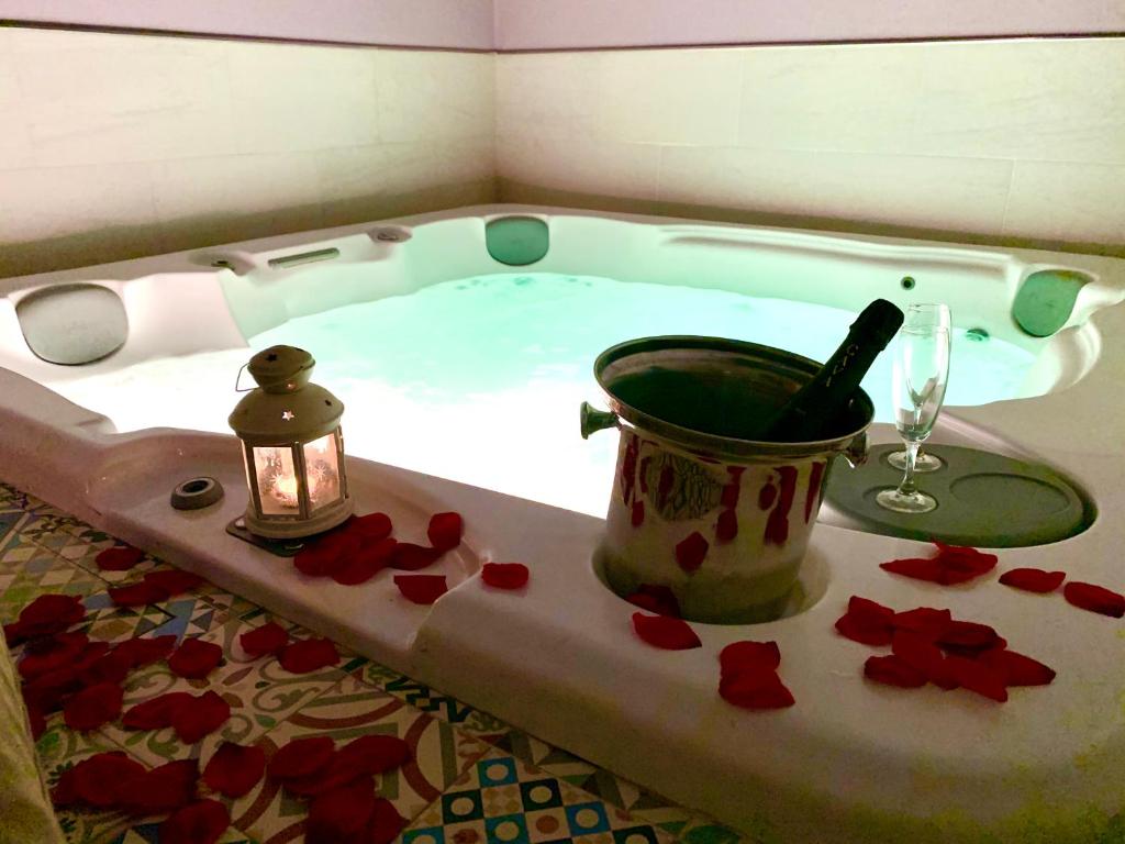 a sink with a bath tub and a vase of flowers at Hotel Spa Adealba in Mérida