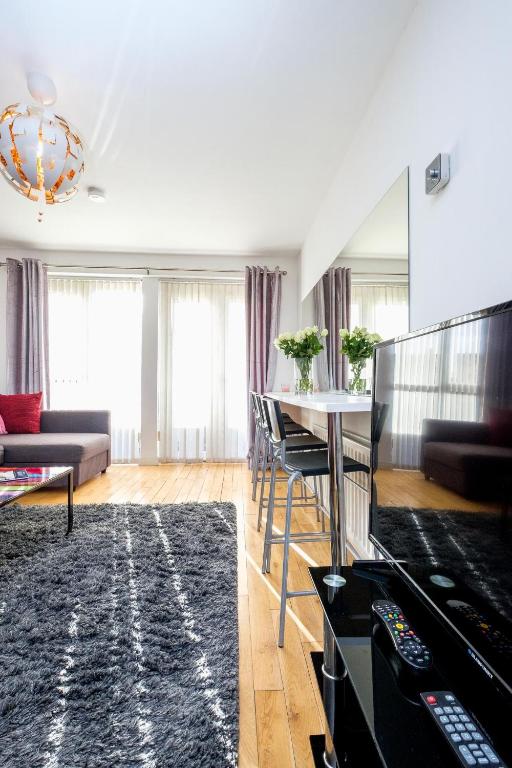a living room with a table and a couch at Ultra Urban Belfast Apartments in Belfast