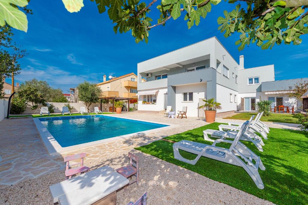 eine Villa mit einem Pool und einem Haus in der Unterkunft Apartment Lari in Privlaka