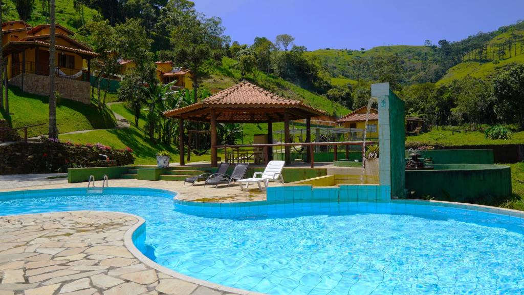 a swimming pool with a gazebo and a house at Pousada Sitio do Visconde in Visconde De Maua