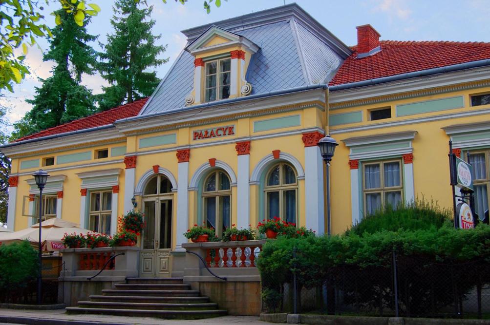 a large yellow building with a red roof at Pensjonat Pałacyk in Łańcut