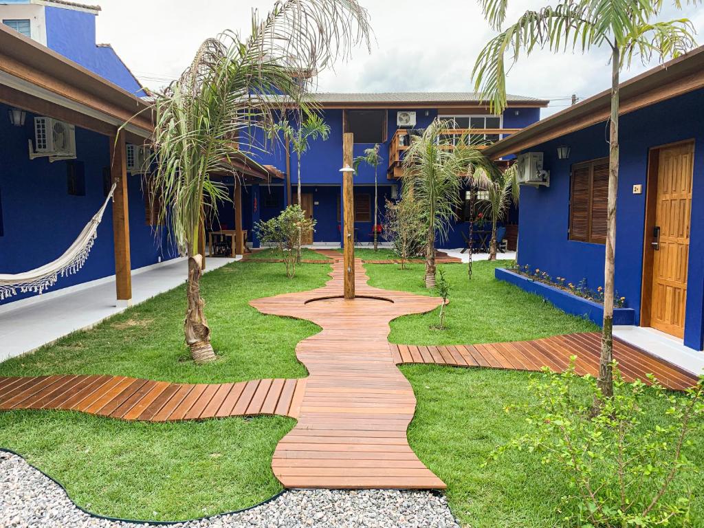 a walkway in front of a house with palm trees at EcoVilla Las Mareas in Maresias