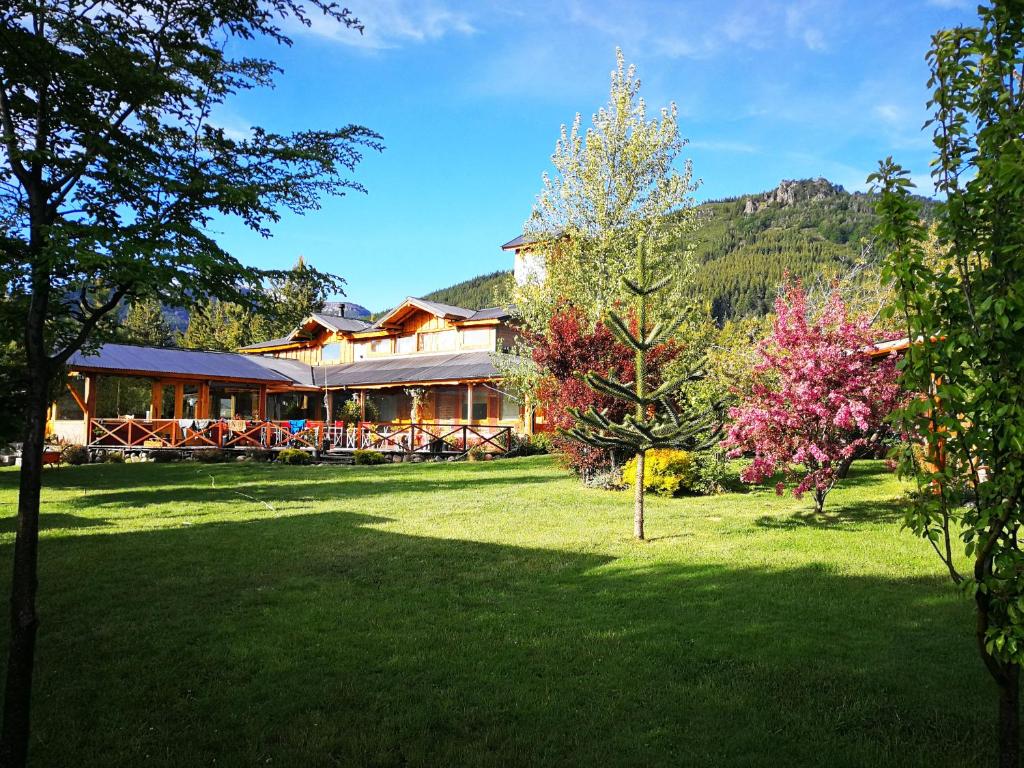a house with a large yard in front of it at Hostería Meliquina in Lago Meliquina