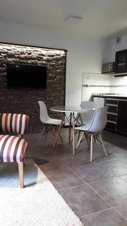 - une table et des chaises dans une pièce dotée d'un mur en briques dans l'établissement monoambiente cerca del centro, à Villa La Angostura