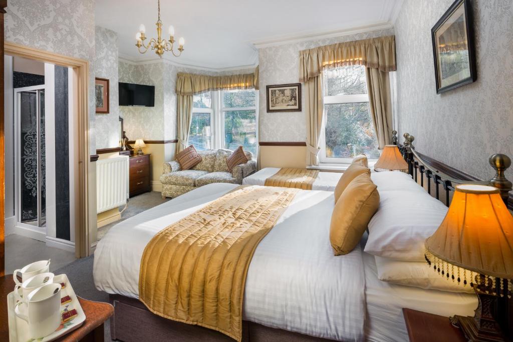 a bedroom with a large bed and a living room at Brookfield B&B Guest House in Keswick