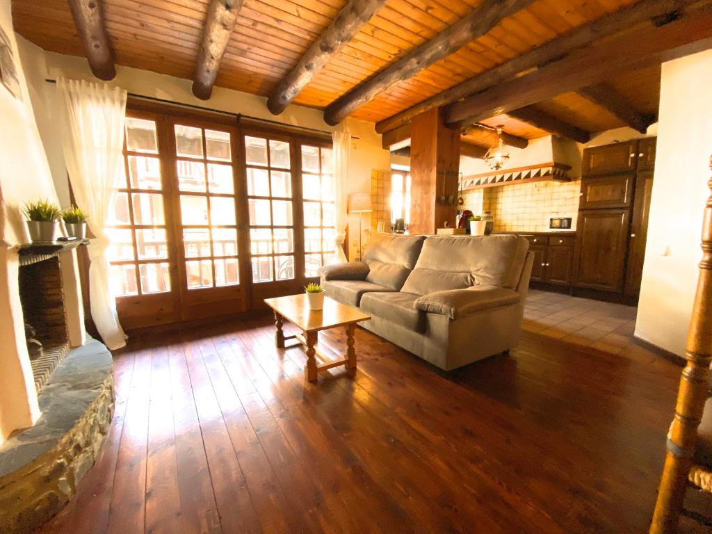 ein Wohnzimmer mit einem Sofa und einem Tisch in der Unterkunft C3 Bordes d'Arinsal, Rustico con Chimenea, Arinsal, Zona Vallnord in Arinsal