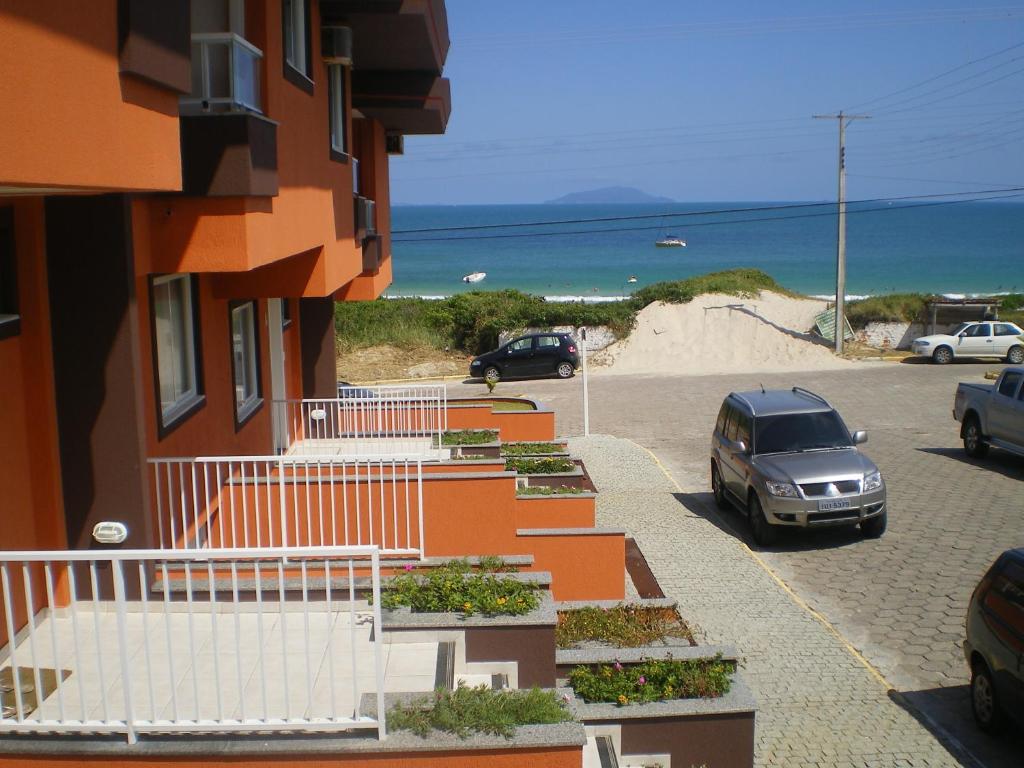 un coche aparcado en un aparcamiento junto a una playa en Praia de Quatro Ilhas a 50 metros do mar, en Bombinhas