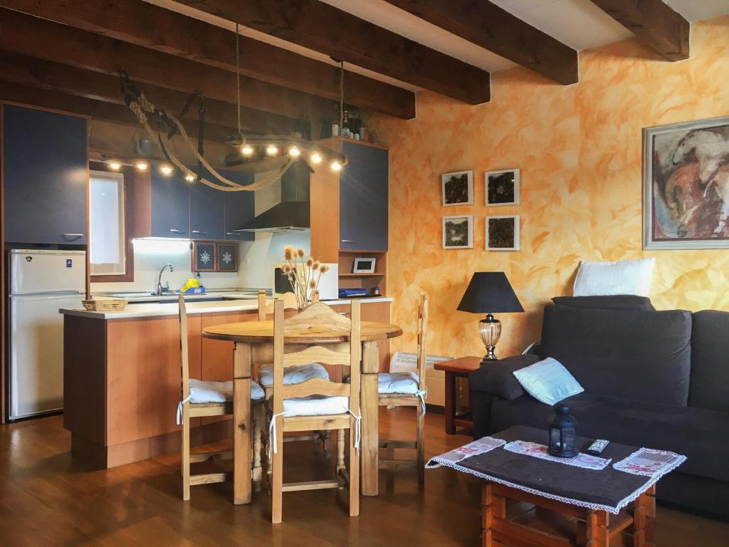 a kitchen and living room with a table and a couch at Duplex Altos De Santiago Buhardilla in Villanúa