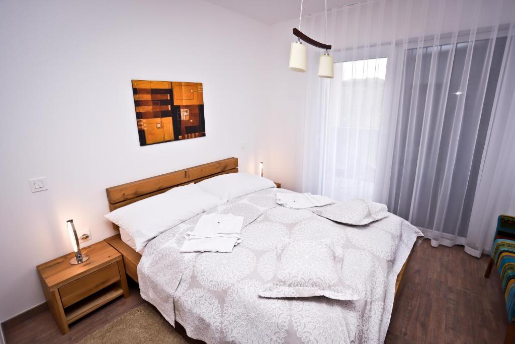 sypialnia z dużym białym łóżkiem z ręcznikami w obiekcie Apartment I&I w Poreču